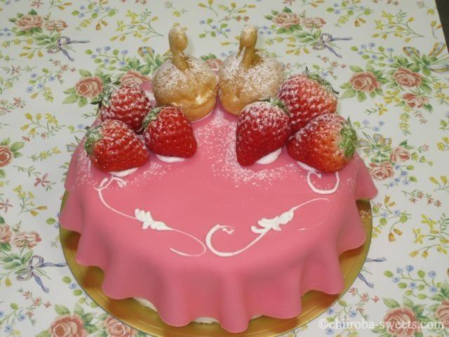 バースデイケーキ３ ピンクのデコレーション１５ｃｍ<br><br>ピンクのチョコレートでフリルの様に飾りました。スワンのシューがお洒落な可愛いデコレーション。中は生クリームのケーキです。￥３８００（４１０４円）：しあわせ菓子工房 SaCHI